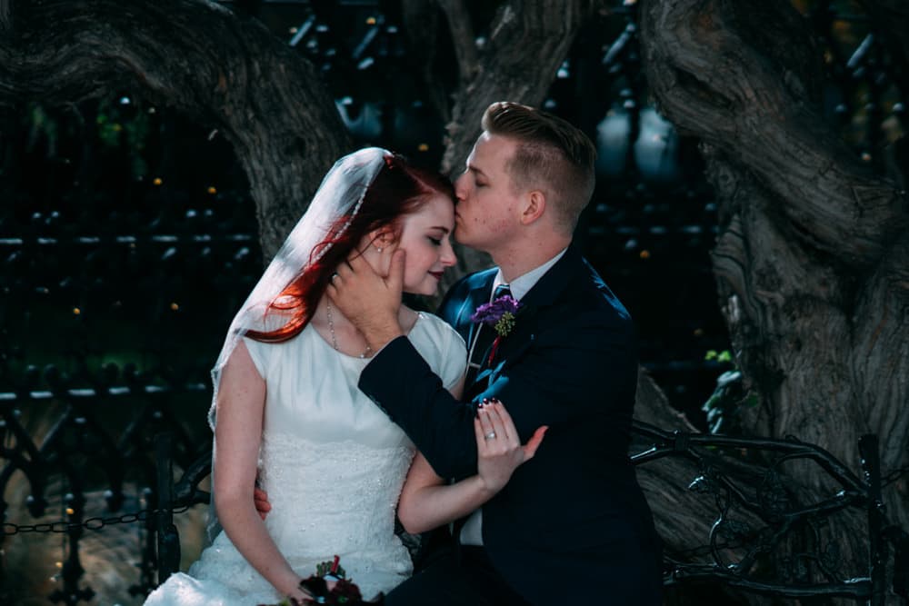 Bride and groom embracing on a bench